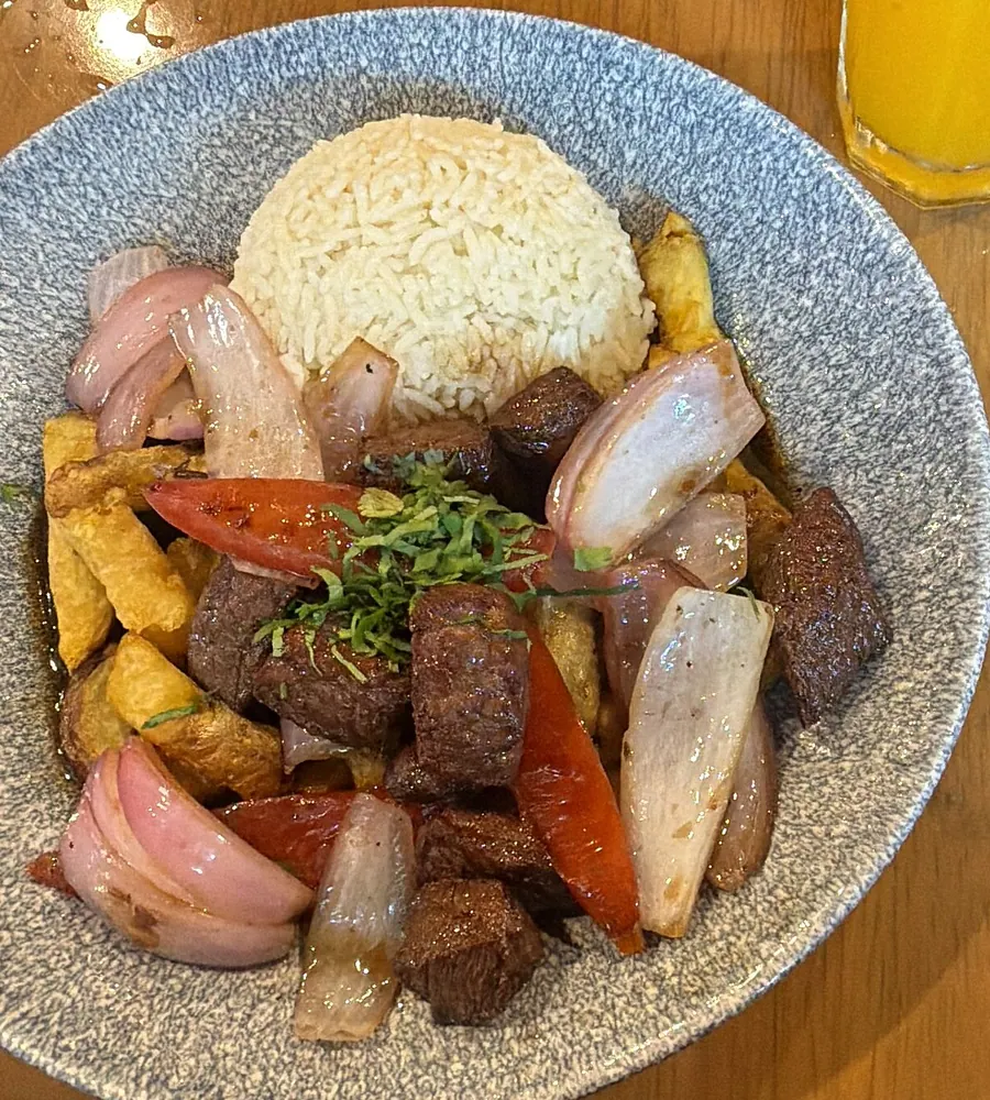 Lomo saltado con arroz blanco, cebolla y tomate